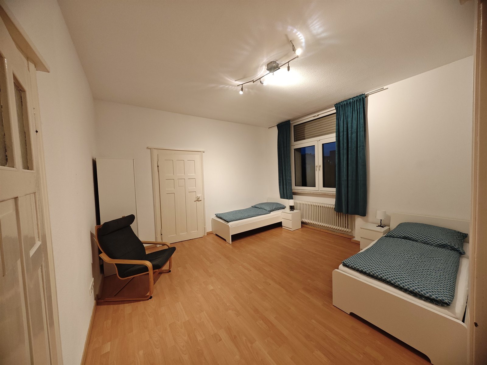Geräumiges Schlafzimmer mit türkisen Vorhängen